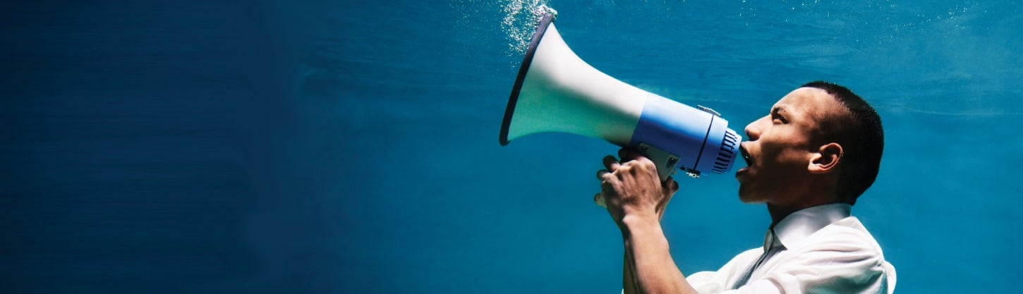 man speaking into megaphone underwater