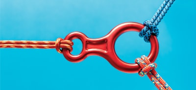 Red carabiner with three ropes attached